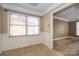 A dining area with windows, tiled floors, and base molding exhibits visible signs of wear and deferred maintenance at 82 Paddington Sw Dr, Concord, NC 28025