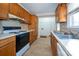 Kitchen featuring wood cabinets, laminate countertops, and appliances at 82 Paddington Sw Dr, Concord, NC 28025