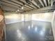 Spacious basement with grey painted concrete flooring and exposed duct work at 925 Belmorrow Dr, Charlotte, NC 28214