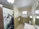 Traditional bathroom showcasing a tiled shower, patterned wallpaper, and a classic vanity at 925 Belmorrow Dr, Charlotte, NC 28214