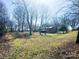 Exterior home view with large yard surrounded by mature trees at 925 Belmorrow Dr, Charlotte, NC 28214