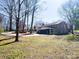 Backyard view of a two-story brick and siding house with mature trees at 925 Belmorrow Dr, Charlotte, NC 28214