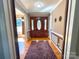 Warm foyer featuring hardwood floors, a decorative rug, and a beautiful wooden door at 925 Belmorrow Dr, Charlotte, NC 28214