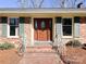 A close-up view of the brick entryway and stained wood front door, framed by sidelights and shutters at 925 Belmorrow Dr, Charlotte, NC 28214