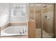 Bathroom showing a shower and a soaking tub with a window at 108 Avaclaire Way, Indian Trail, NC 28079