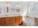 Bathroom featuring double sinks, a soaking tub, and tile accents at 108 Avaclaire Way, Indian Trail, NC 28079