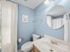 Bathroom with blue walls, vanity, modern toilet, and round mirror at 108 Avaclaire Way, Indian Trail, NC 28079