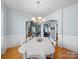 Open dining room with hardwood floors, white wainscoting, and decorative chandelier, creating an elegant atmosphere at 108 Avaclaire Way, Indian Trail, NC 28079