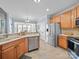 Well-lit kitchen with stainless steel appliances, tile flooring, and wood cabinets at 108 Avaclaire Way, Indian Trail, NC 28079