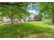 Spacious backyard with lush green grass, mature trees, and a fenced perimeter for privacy at 111 Harris Farm Rd, Mooresville, NC 28115