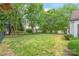 Lush backyard with green grass, mature trees, and a black metal fence, offering a serene outdoor space and privacy at 111 Harris Farm Rd, Mooresville, NC 28115