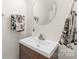 Bathroom featuring a modern white vanity with round mirror and decorative hand towels at 111 Harris Farm Rd, Mooresville, NC 28115