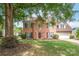 Charming two-story brick home with a well-manicured lawn and mature tree providing shade at 111 Harris Farm Rd, Mooresville, NC 28115