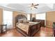 Main bedroom with tray ceilings, hardwood floors, dresser, and a large upholstered bed at 111 Harris Farm Rd, Mooresville, NC 28115