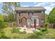 Brick home exterior featuring a patio with a seating area, a well-maintained lawn, and mature landscaping at 1120 Millwright Ln, Matthews, NC 28104