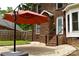 Enjoy outdoor relaxation on the patio of this brick home, with a red umbrella and privacy fence at 1120 Millwright Ln, Matthews, NC 28104