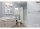 Well-lit bathroom featuring a single sink vanity, a medicine cabinet, and a shower-tub combo with a white shower curtain at 1120 Millwright Ln, Matthews, NC 28104