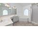Bright bathroom featuring a large soaking tub, tiled floors, and a walk-in shower at 1120 Millwright Ln, Matthews, NC 28104