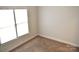This bedroom features plush carpeting and a window that brings in plenty of natural light at 1120 Millwright Ln, Matthews, NC 28104