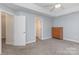 Comfortable bedroom with multiple doors and gray carpet, with a dresser in the corner at 1120 Millwright Ln, Matthews, NC 28104