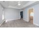 Spacious bedroom with gray carpet, tray ceilings, and an ensuite bathroom with large tub at 1120 Millwright Ln, Matthews, NC 28104
