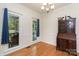 Dining room with hardwood floors, a chandelier, and natural light from windows with backyard view at 1120 Millwright Ln, Matthews, NC 28104