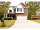 Charming two-story home featuring a brick and white facade, inviting front porch, and a well-manicured lawn at 1120 Millwright Ln, Matthews, NC 28104