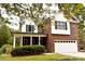Charming two-story home featuring a brick and white facade, inviting front porch, and a well-manicured lawn at 1120 Millwright Ln, Matthews, NC 28104