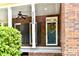 Inviting front porch with brick columns, ceiling fan, and decorative wreath on the front door at 1120 Millwright Ln, Matthews, NC 28104