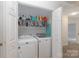 Laundry room with white washer and dryer; storage shelf above with hangers and supplies at 1120 Millwright Ln, Matthews, NC 28104