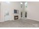 Bright living room with fireplace, neutral carpet, high ceilings, and abundant natural light at 1120 Millwright Ln, Matthews, NC 28104