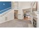 View of a living room with staircase, leading to a bright, white kitchen with stainless appliances at 1120 Millwright Ln, Matthews, NC 28104