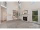 Open-concept living area featuring a fireplace, tall ceilings, neutral carpet, and access to the kitchen at 1120 Millwright Ln, Matthews, NC 28104