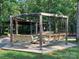Inviting outdoor seating area with circular benches and a wooden pergola for relaxing and socializing with neighbors at 1120 Millwright Ln, Matthews, NC 28104