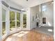 Sunroom featuring a fireplace, natural light, and wood flooring overlooking a landscaped backyard at 1120 Millwright Ln, Matthews, NC 28104