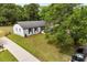 An elevated view of a cozy home with a lush green lawn, mature trees, and private drive at 1316 Fox Run Dr, Charlotte, NC 28212