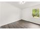 Cozy bedroom with hardwood floors and a large window overlooking the yard at 1316 Fox Run Dr, Charlotte, NC 28212