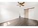 Bright bedroom with dark hardwood floors, ceiling fan, and rustic sliding barn door at 1316 Fox Run Dr, Charlotte, NC 28212
