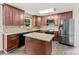 Well-lit kitchen with stainless steel fridge, stone countertops, and dark cabinetry at 1316 Fox Run Dr, Charlotte, NC 28212