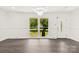 Bright living room with refinished hardwood floors, modern light fixture, and large window showcasing a manicured front yard at 1316 Fox Run Dr, Charlotte, NC 28212