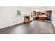 Open-concept living room with a stone fireplace, dark wood floors, and a seamless transition to the modern kitchen at 1316 Fox Run Dr, Charlotte, NC 28212
