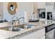 A stainless steel kitchen sink, faucet, and dishwasher complemented by white cabinets and granite countertops at 1435 Mammoth Rd, Hickory, NC 28602