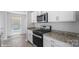 Modern kitchen featuring stainless steel appliances, granite countertops, white cabinetry, and vinyl flooring at 1439 Mammoth Rd, Hickory, NC 28602