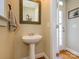 Charming powder room with pedestal sink, framed mirror, and neutral color scheme at 151 E Morehouse Ave, Mooresville, NC 28117