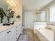 A bright bathroom features a double sink vanity, a large mirror, a soaking tub, and a glass shower at 151 E Morehouse Ave, Mooresville, NC 28117