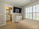 Bedroom featuring an ensuite bathroom, dresser, and a bright window at 151 E Morehouse Ave, Mooresville, NC 28117