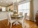 Bright dining area with a chandelier, hardwood floors, and a view of the kitchen at 151 E Morehouse Ave, Mooresville, NC 28117