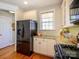 Bright kitchen featuring stainless steel refrigerator, granite counters, and white cabinetry at 151 E Morehouse Ave, Mooresville, NC 28117