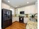 Well-lit kitchen with stainless steel appliances, granite countertops, and hardwood floors at 151 E Morehouse Ave, Mooresville, NC 28117