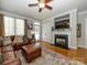 Living room featuring a fireplace, hardwood floors, and a comfortable leather sectional at 151 E Morehouse Ave, Mooresville, NC 28117